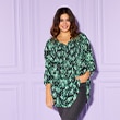 The model is wearing a green patterned blouse 