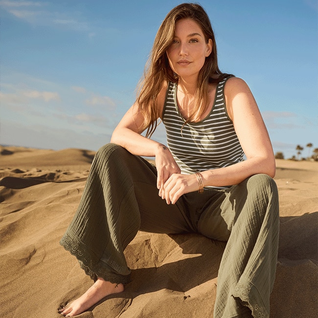 The model is wearing colorful pants