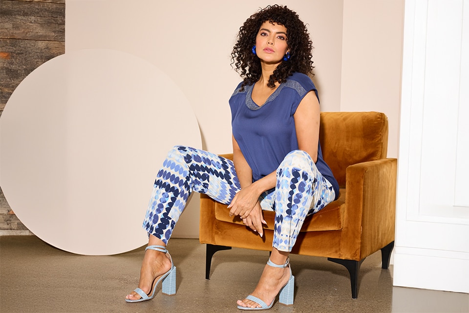 The model is wearing plaid pants and a lilla top