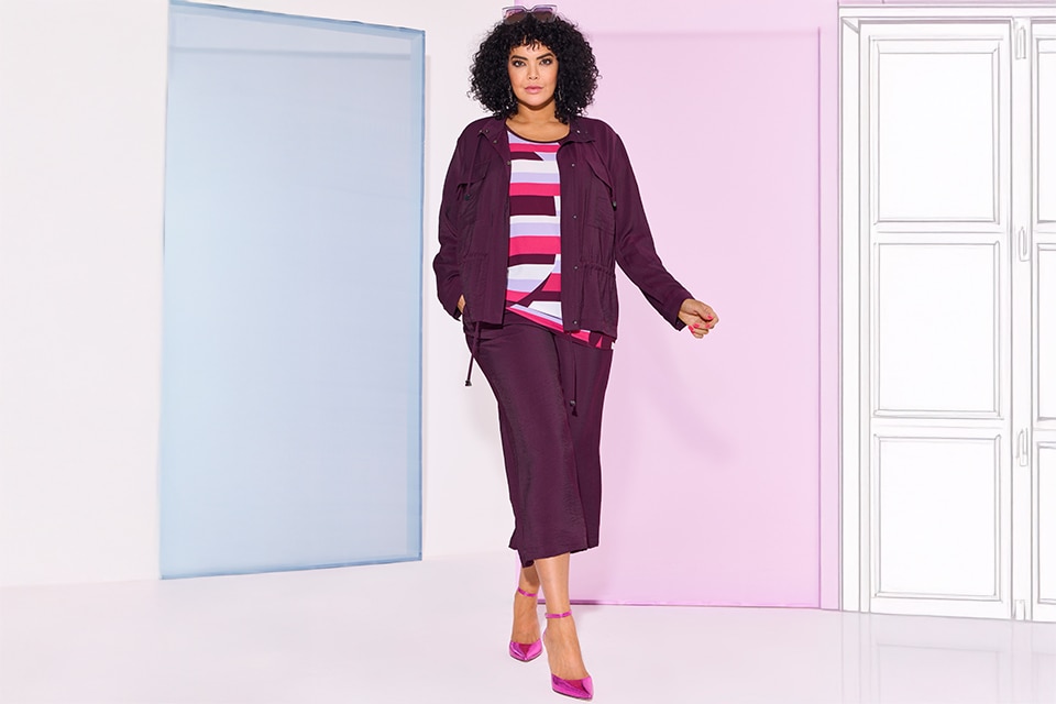 The model wears a purple jacket with pants of the same color

