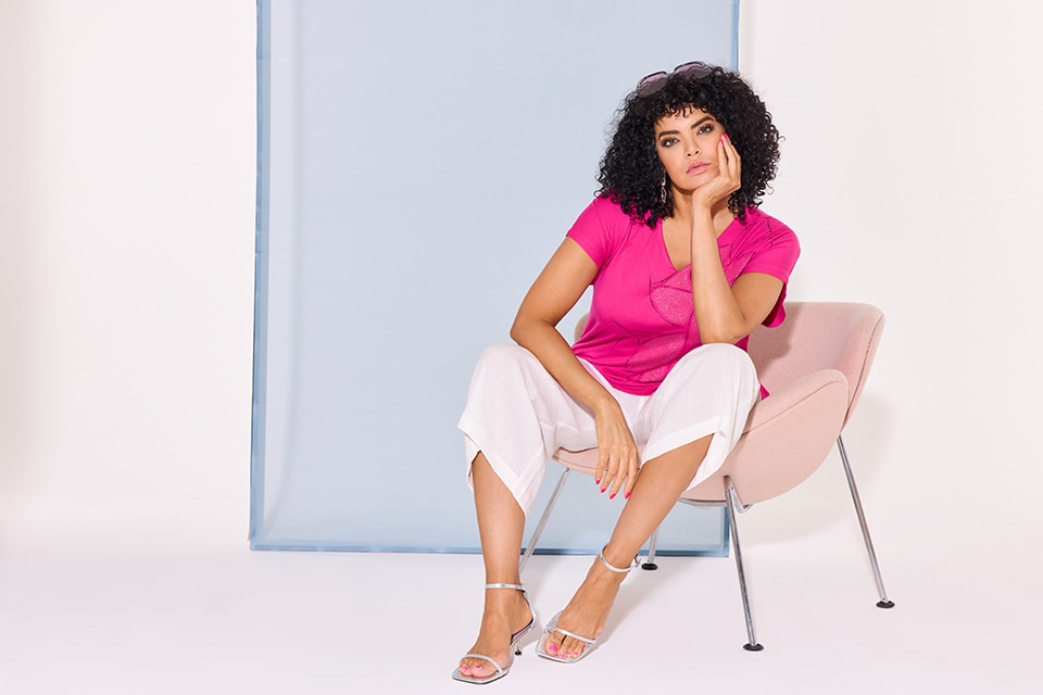 The model wears a pink tshirt with white pants
        
