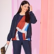 The model wears a blue cardugan with a patterned tshirt

