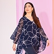 The model wearsa blue blouse with flowers

