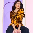 The model wears a black and orange shirt