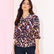 The model wears a colorful blouse