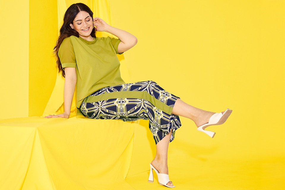 The model is wearing culottes with a graphic print
