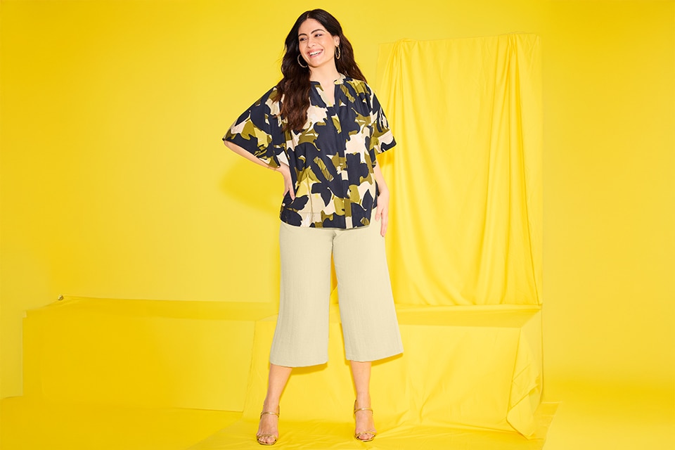 The model is wearing a blouse with a floral print