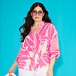 The model is wearing a white and pink blouse