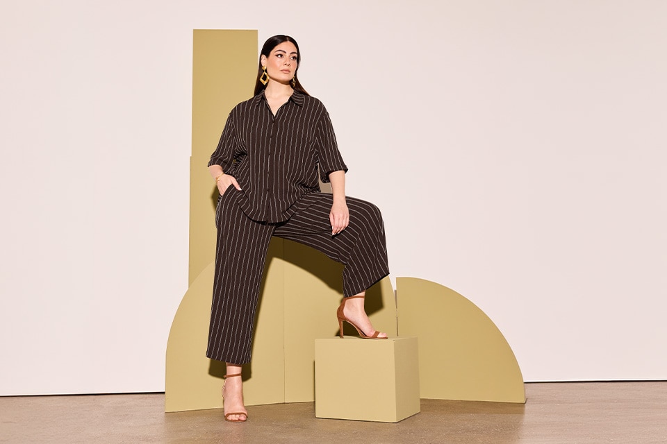 The model is wearing a brown blouse and a brown trousers.