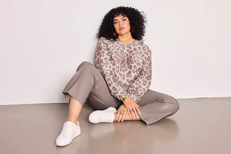 The model is wearing a beige leoprint shirt and a beige leather pants.