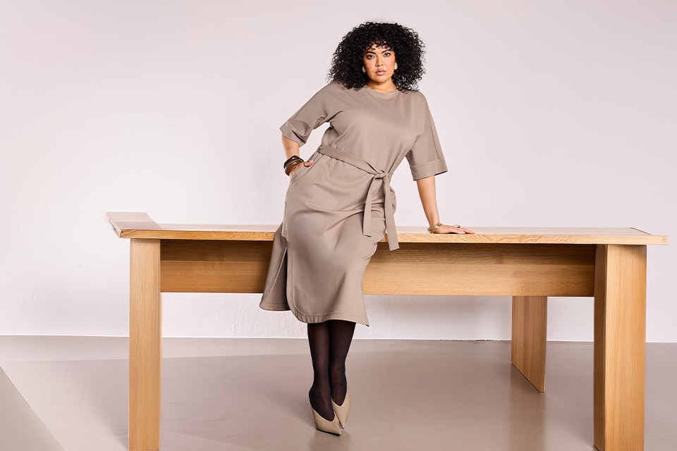 The model is wearing a beige dress.
