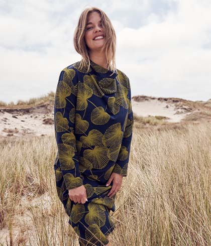 The model poses in a blouse and trousers 