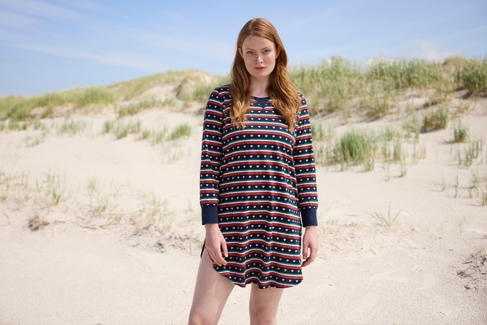 The model poses on the sidelines wearing a striped nightgown 