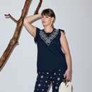 The model is wearing stylish black shorts with a print on the side