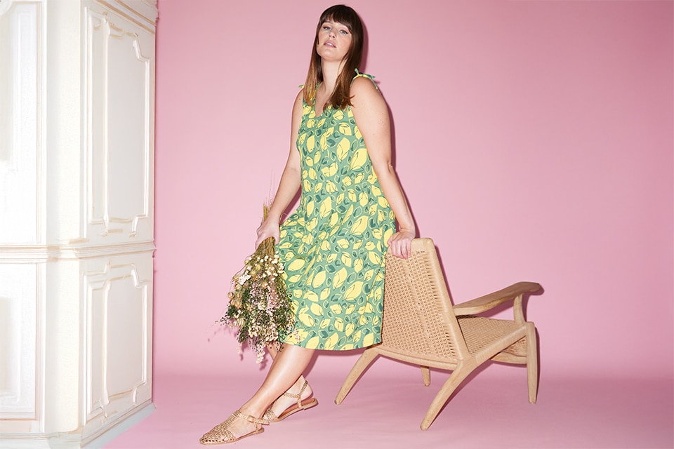 The model is wearing a green and yellow patterned dress
