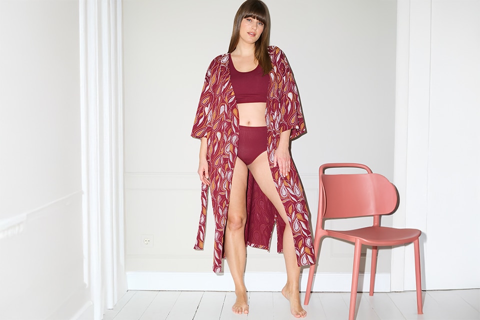 The model is wearing a wine-red bathrobe and matching underwear in the same color.