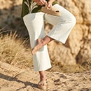 The model is wearing a beige blouse paired with a black skirt featuring a matching print.
