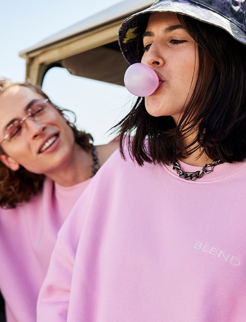 Male and female model wearing pink sweaters
