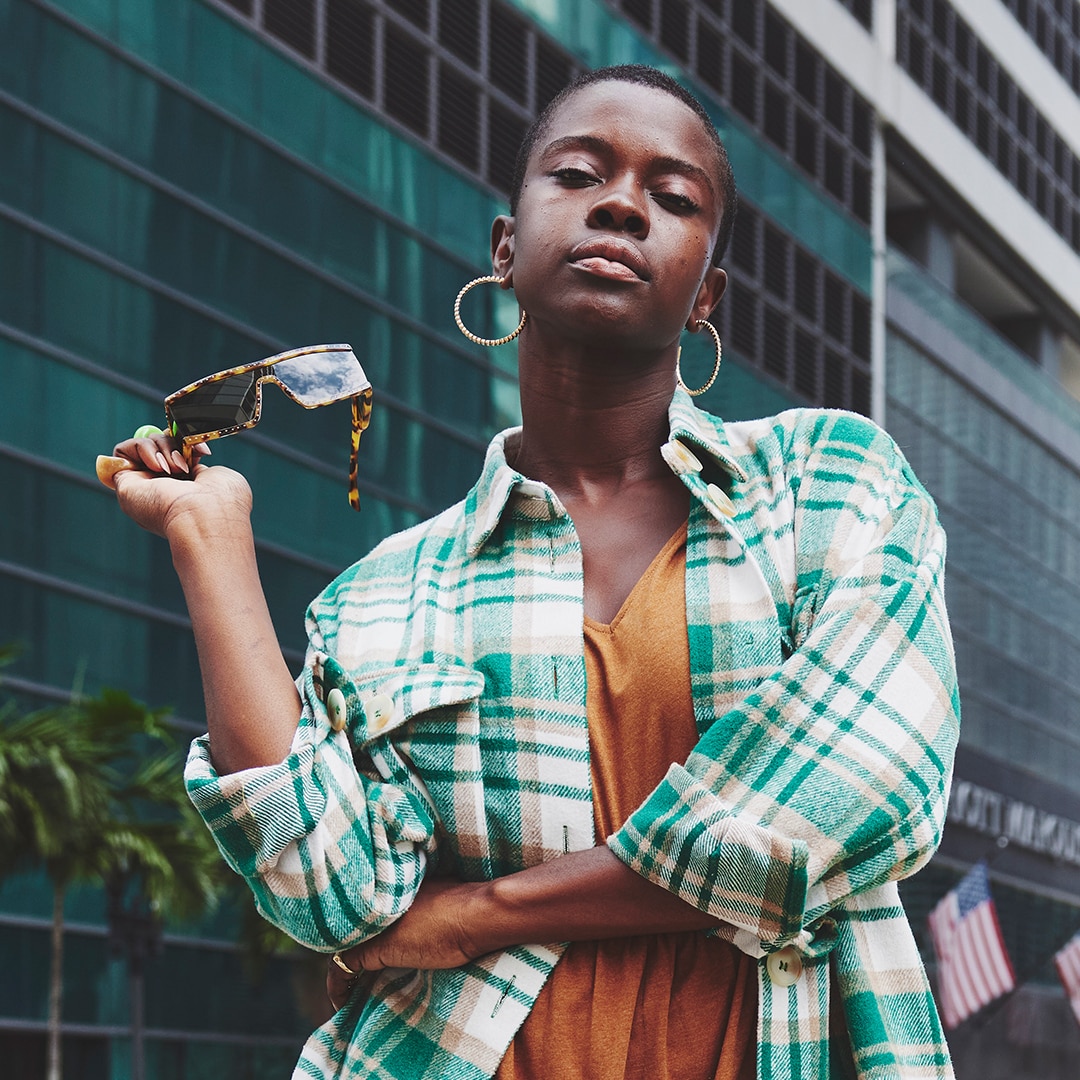 Dark-skinned model is wearing a check shirt and an orange top