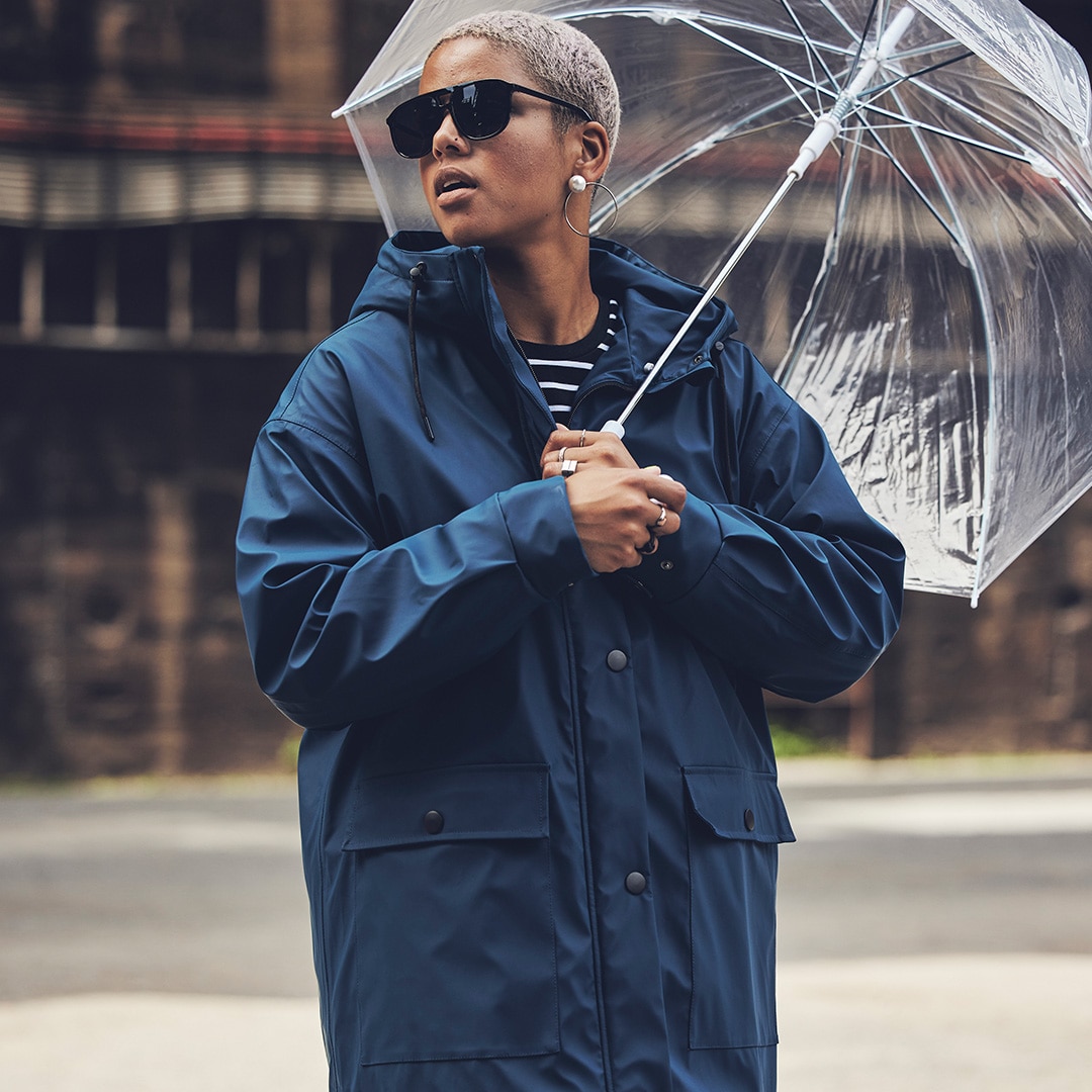 Frau mit blauer Jacke und Regenschirm