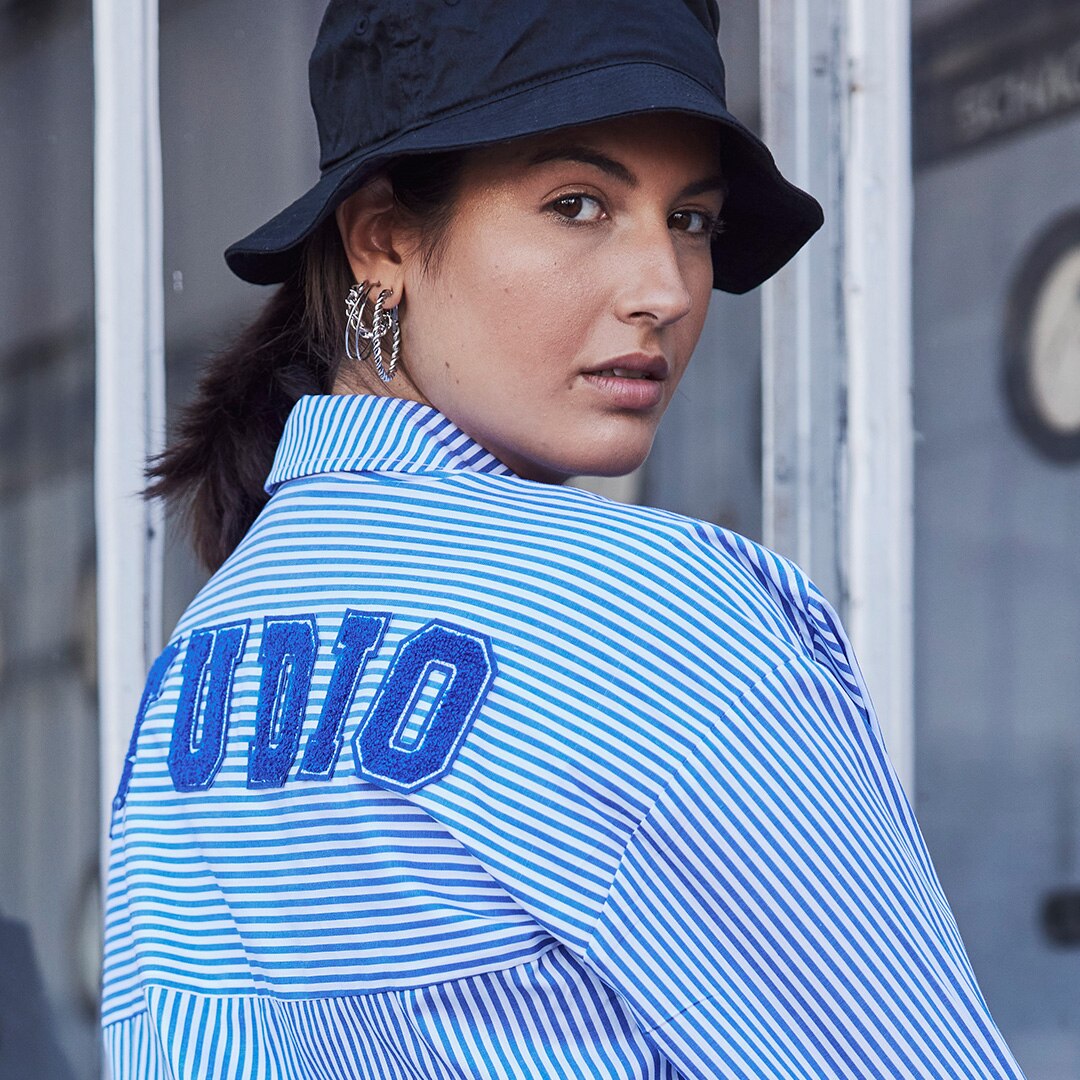 Close-up of a model with white blue striped blouse and blue hat