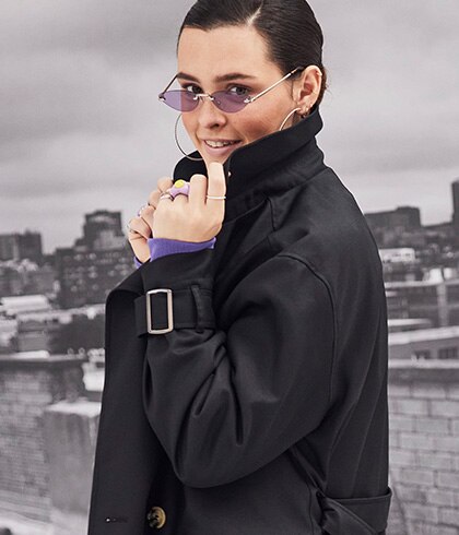 Model wearing a black coat and sunglasses