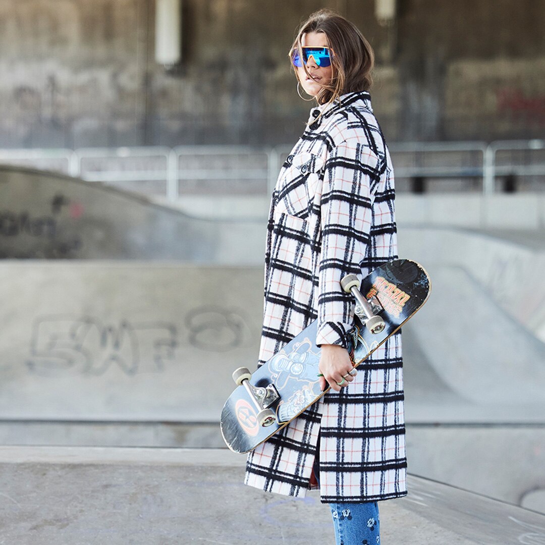 Woman is wearing a long plaid jacket