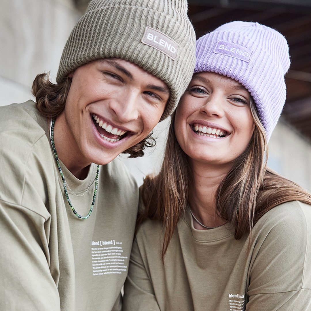 Two people wearing matching beanies