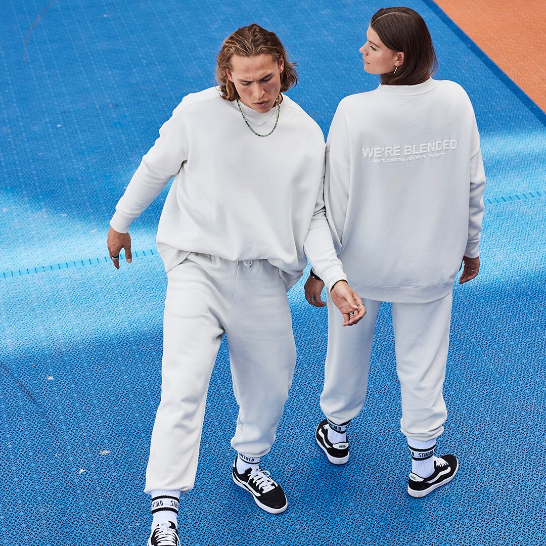 Two people wearing mathing white sweatsuites