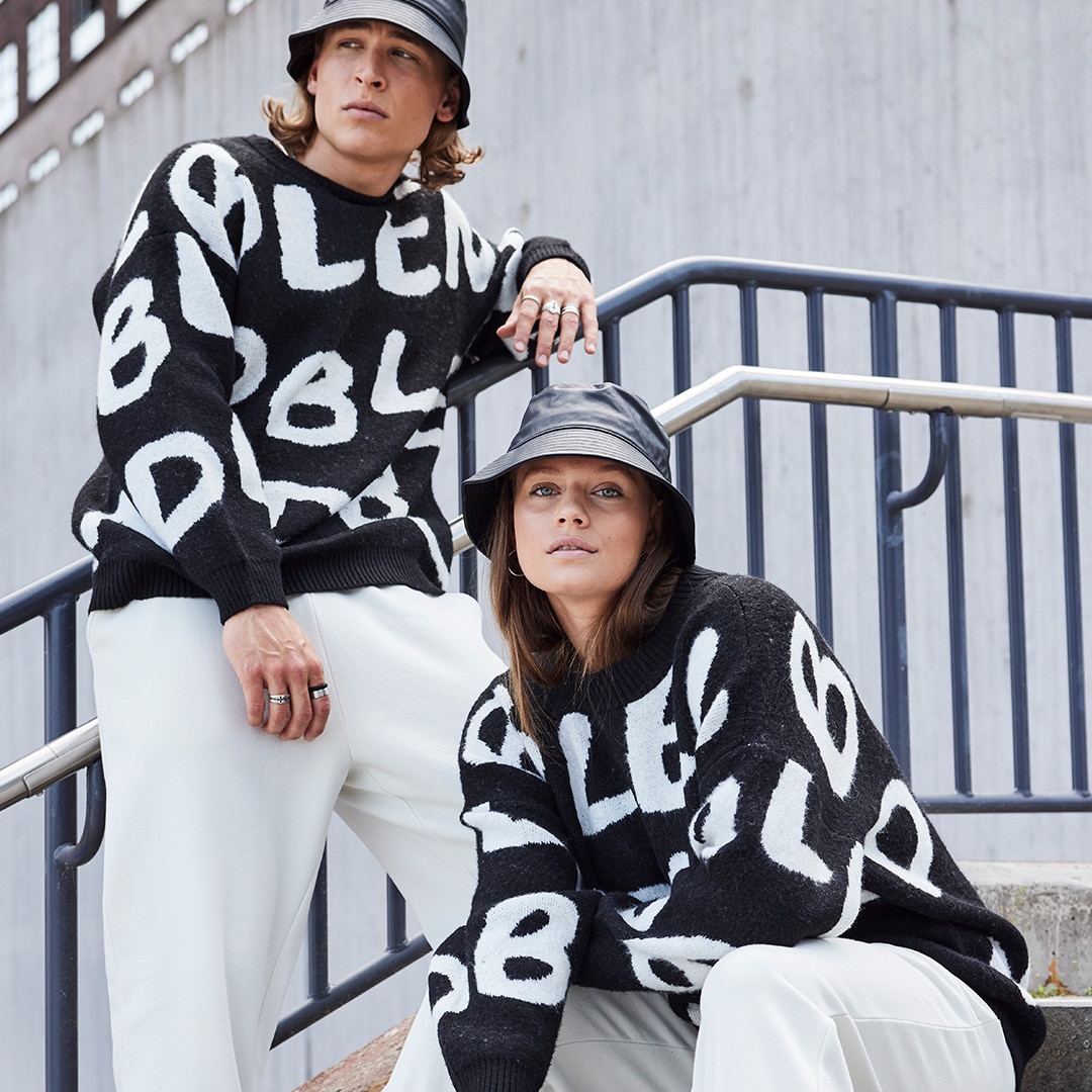 Two models wearing the same black and white outfit