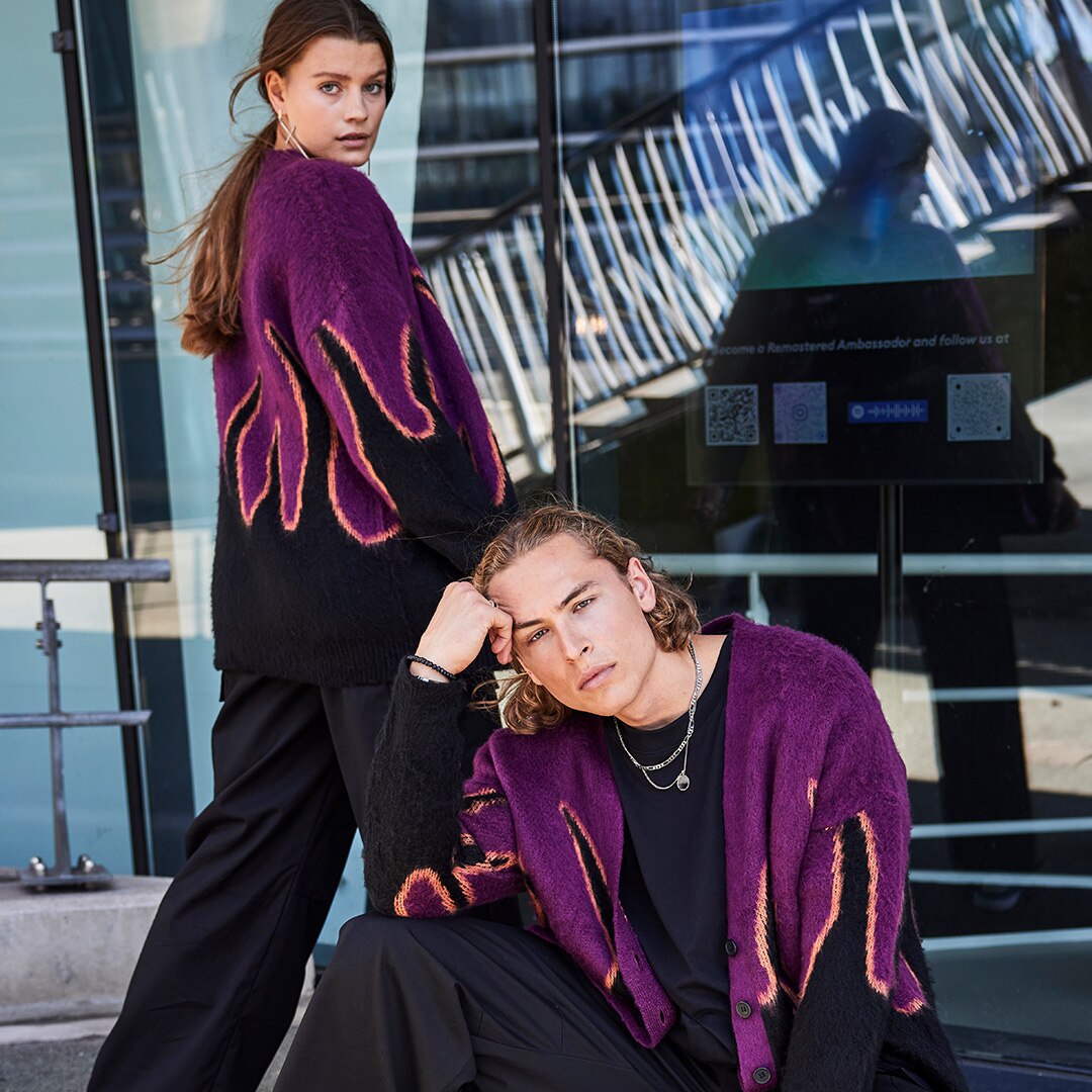 Two models wearing the same black / violet sweatshirt with a pattern