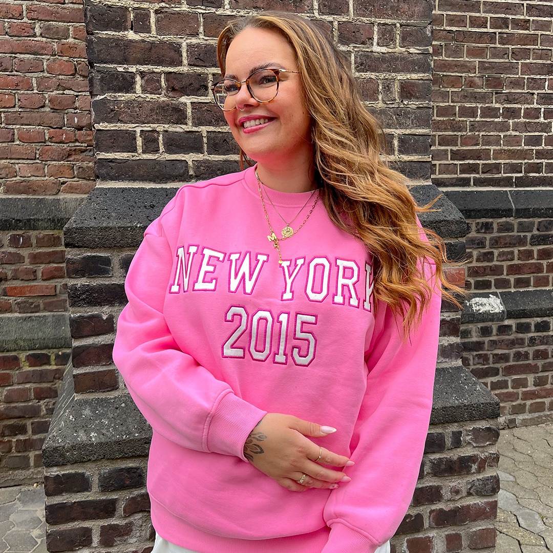 The girl is wearing a light pink blazer in a loose fit style