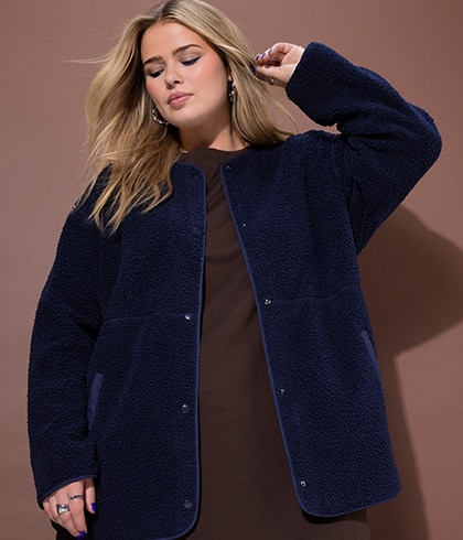 The model is wearing a black and white college jacket.