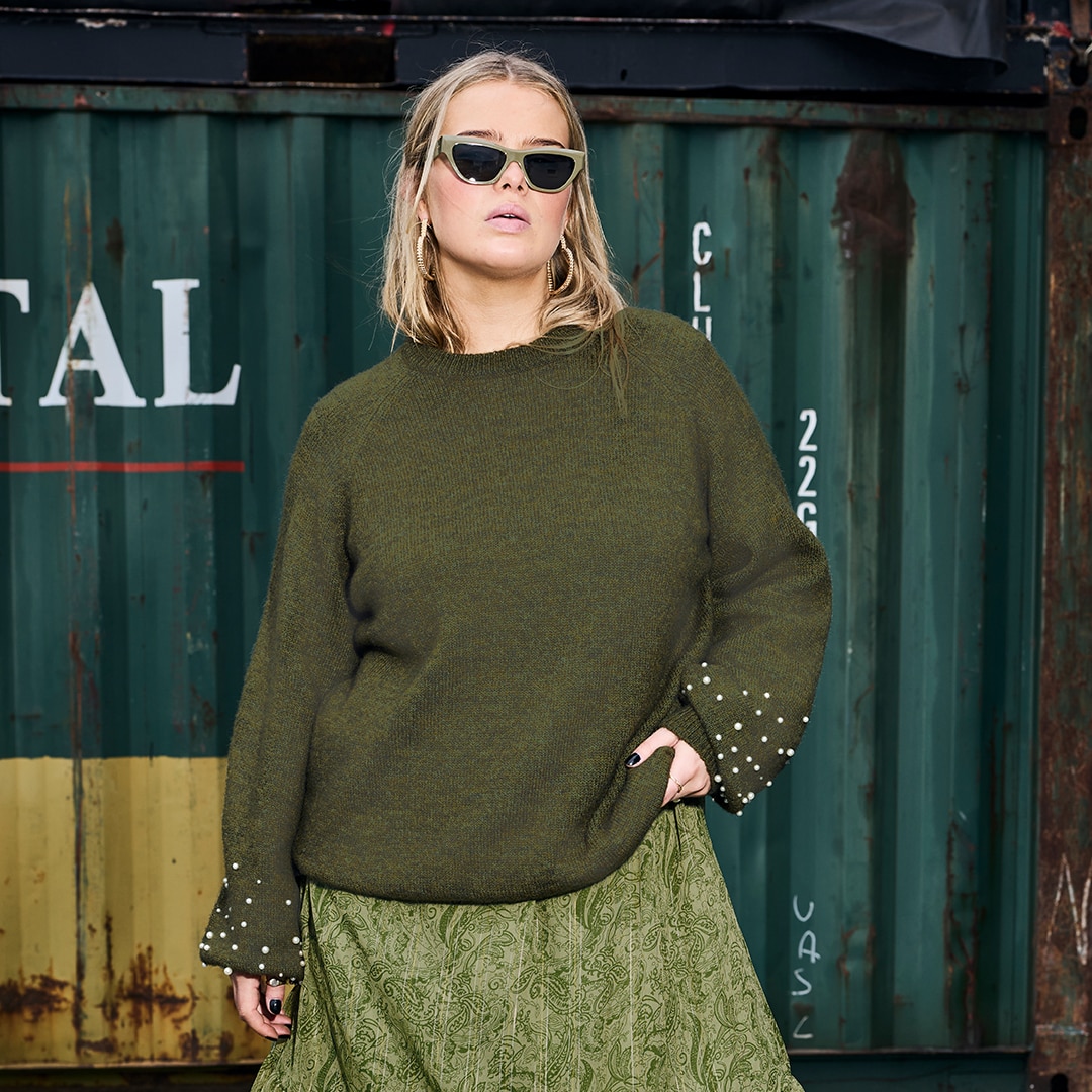 Model is wearing a green white purple pullover 