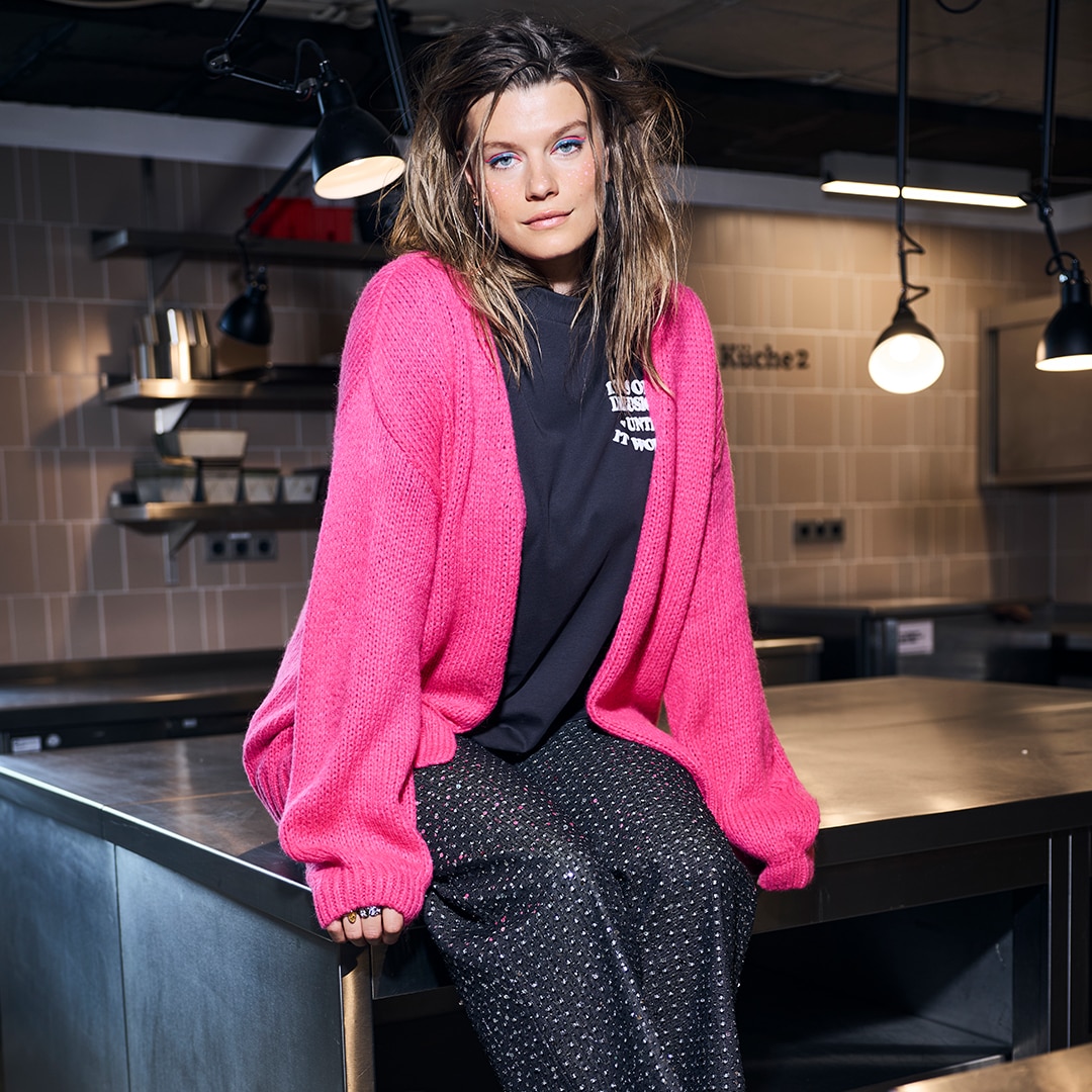 The model is wearing a black jersey midi dress, oversized with a round neck and sleeveless