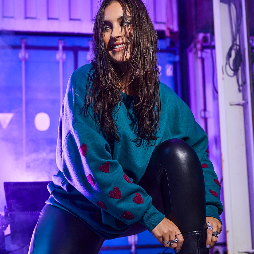 The girl is wearing a light pink blazer in a loose fit style