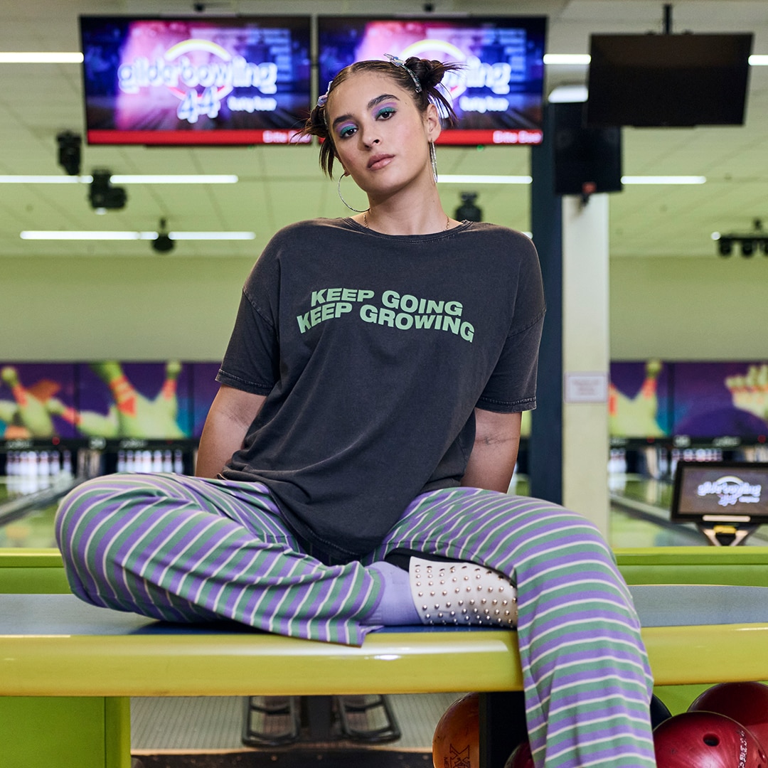 The model is wearing a black jersey midi dress, oversized with a round neck and sleeveless