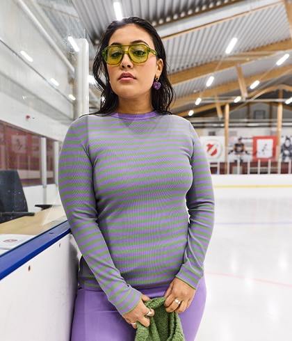 The model is wearing a black shirt and burgundy trousers with a diamond-shaped pattern.