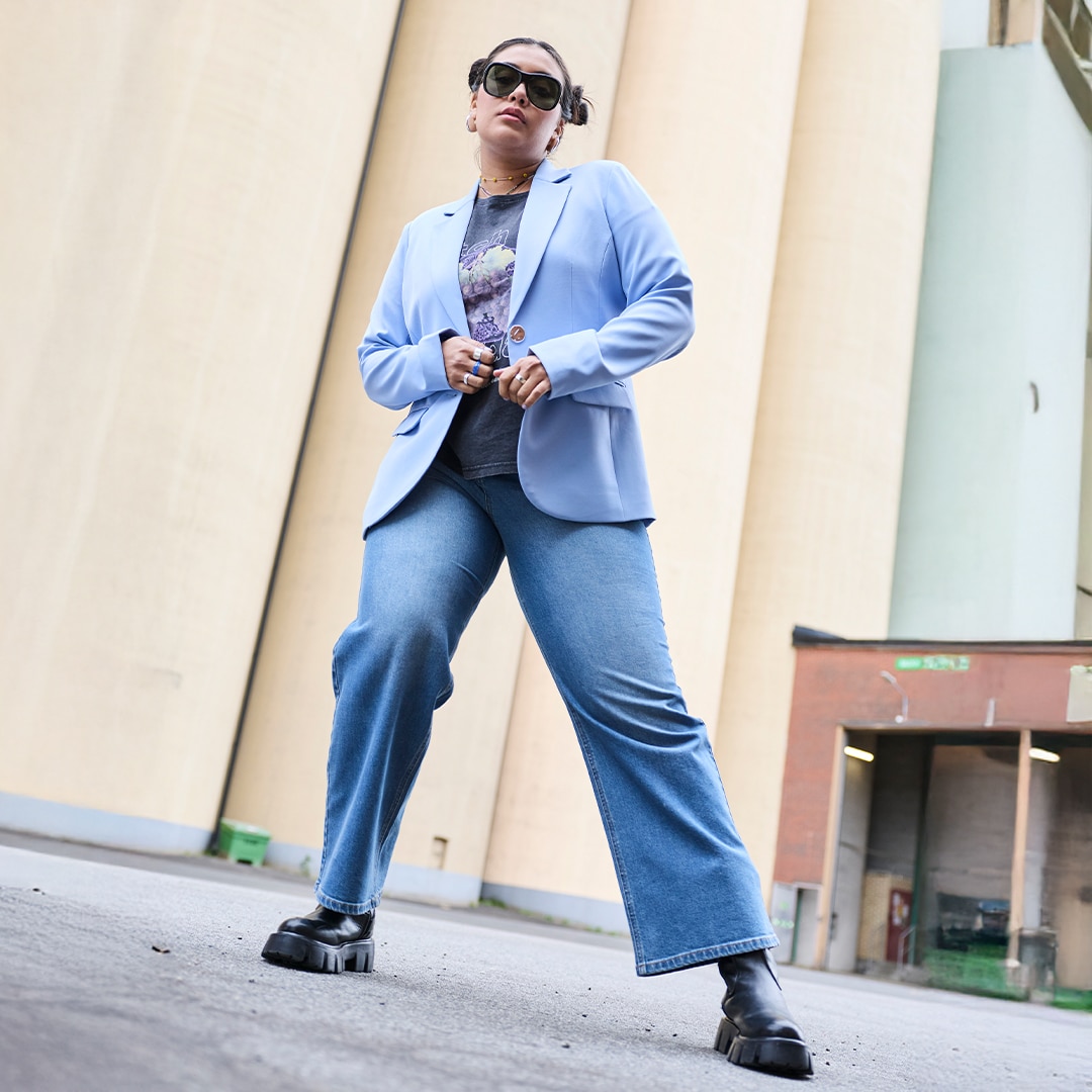 The model wears a light purple blazer combined with a band T-shirt and jeans.