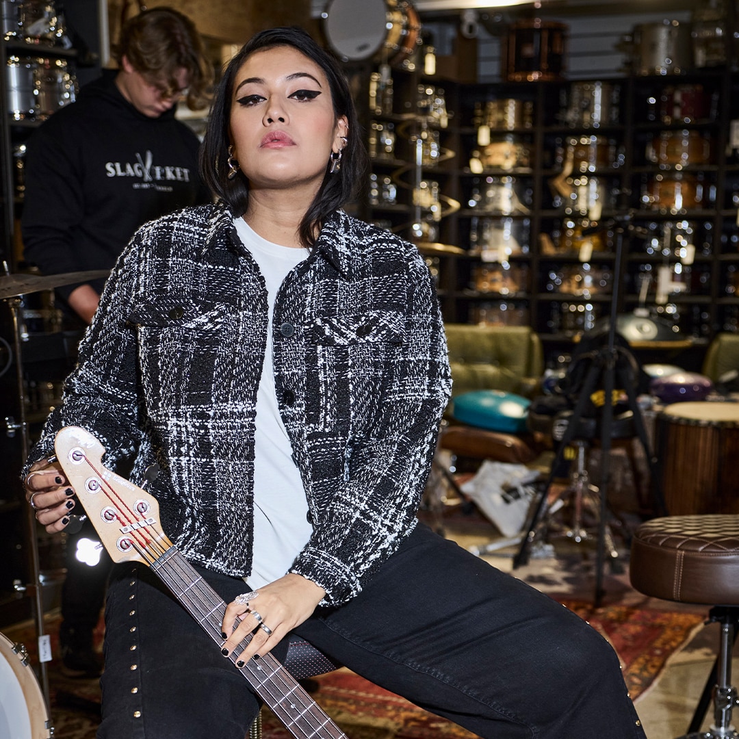 The model is wearing a black and white checked short jacket.