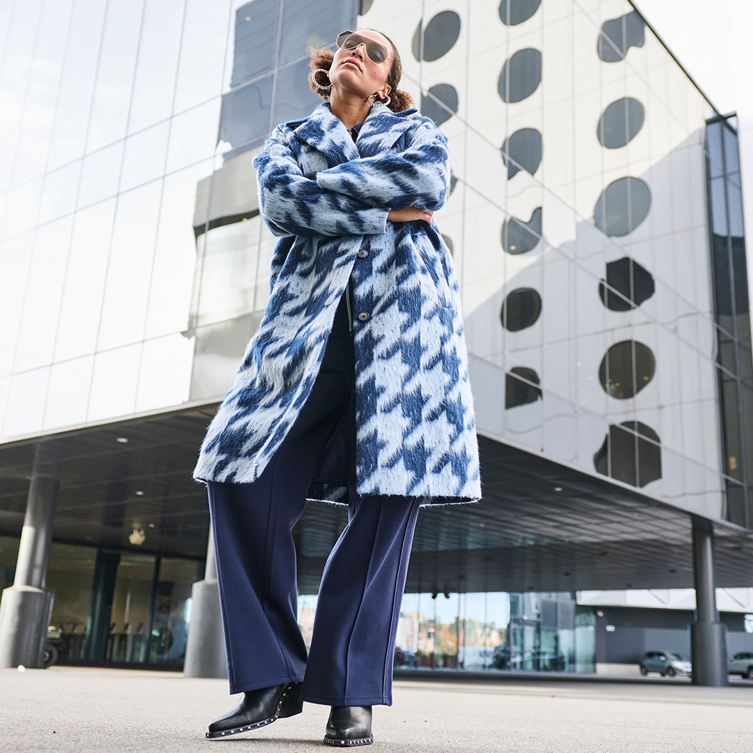 The model wears a light purple blazer combined with a band T-shirt and jeans.