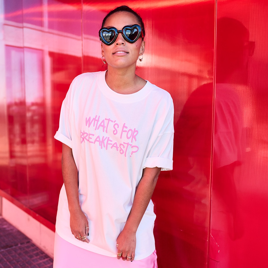 The model is wearing a light blue sweater with a floral print on the back.