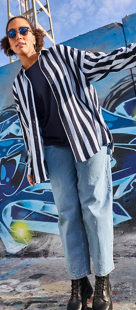 The model is wearing a neon green sweatshirt with leggings and cowboy boots.