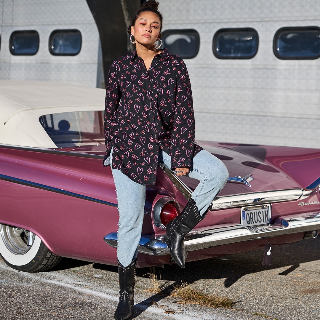 The model is wearing a black sweatshirt dress with very attractive black and white cowboy boots.