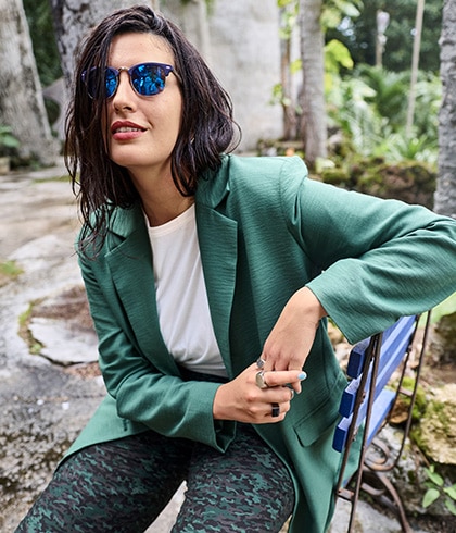 The model is wearing a black shirt and burgundy trousers with a diamond-shaped pattern.