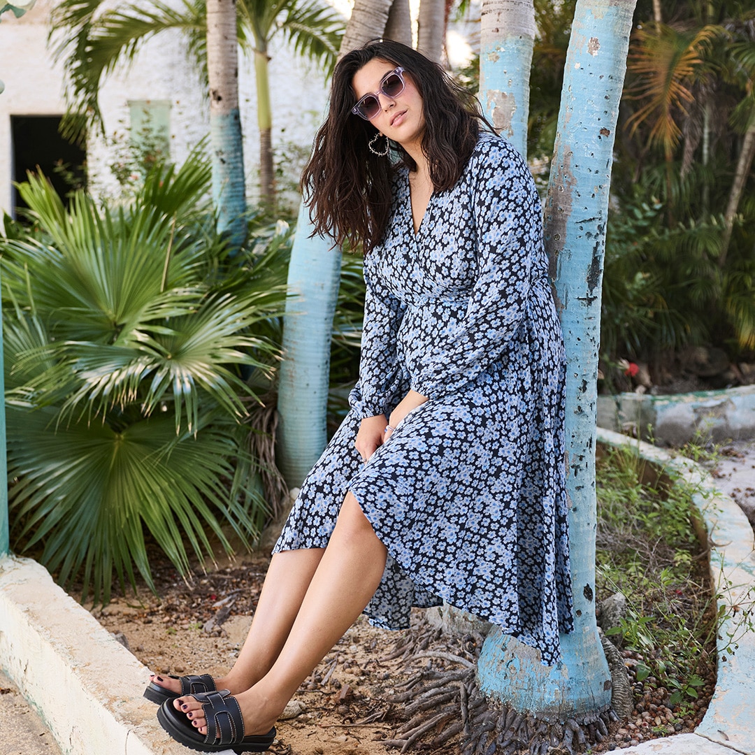 The model is wearing a purple football shirt with green numbers on the front.