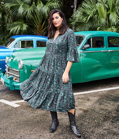 The model is wearing a neon green sweatshirt with leggings and cowboy boots.