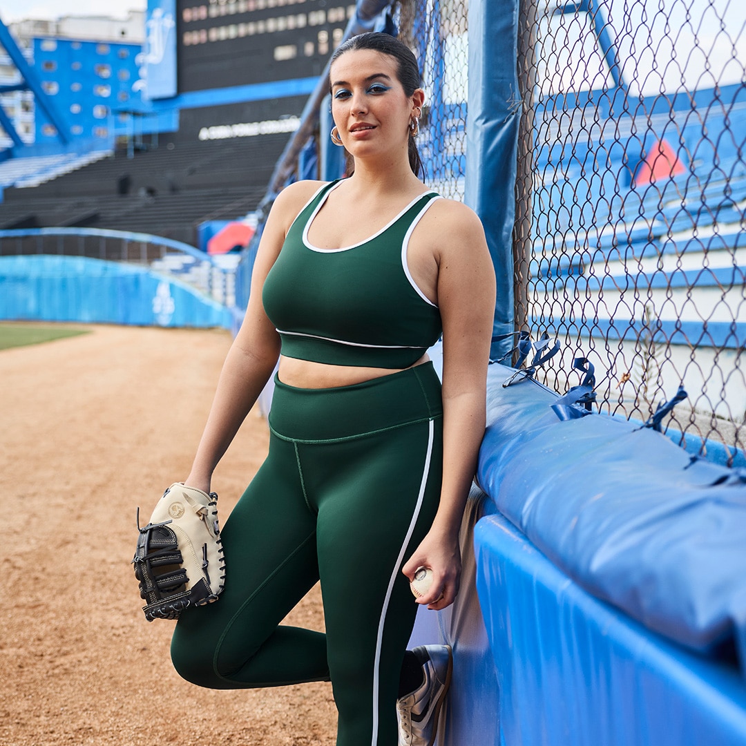 The model is wearing a purple sweater and a short black patterned skirt.