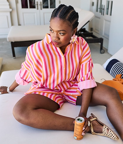 The model is wearing an orange and pink striped blouse
