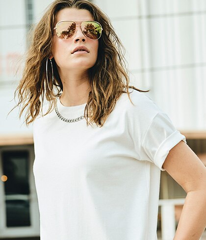 Woman with sunglasses and a white t-shirt.